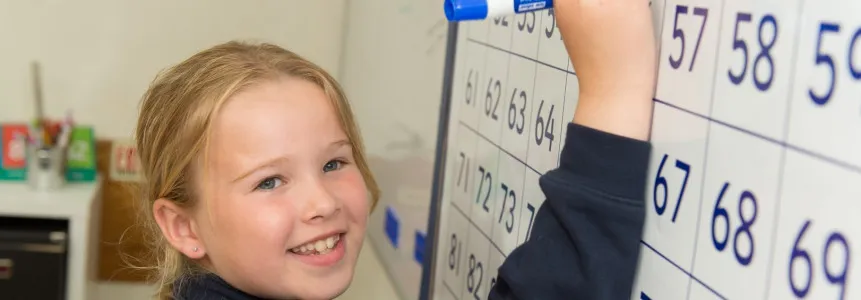 child writing on white board - CVP